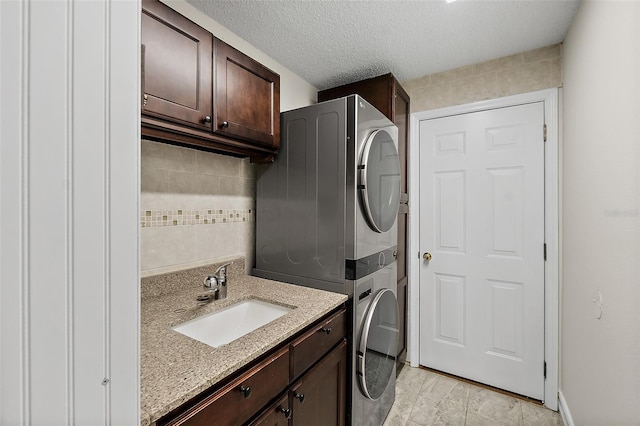 7 Zeolite Pl, Palm Coast, FL 32164 - laundry room featuring stacked washer / drying machine, cabinet space, and a textured ceiling