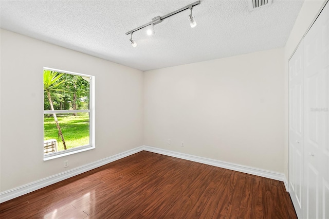 7 Zeolite Pl, Palm Coast, FL 32164 - empty room with track lighting, dark wood finished floors, and a textured ceiling