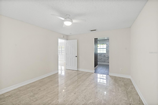 7 Zeolite Pl, Palm Coast, FL 32164 - unfurnished room with light marble finish floors, a ceiling fan, and a textured ceiling