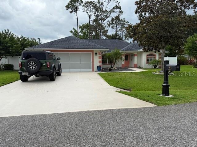 23 Foxhall Ln, Palm Coast, FL 32137 - single story home with driveway, a garage, and a front yard