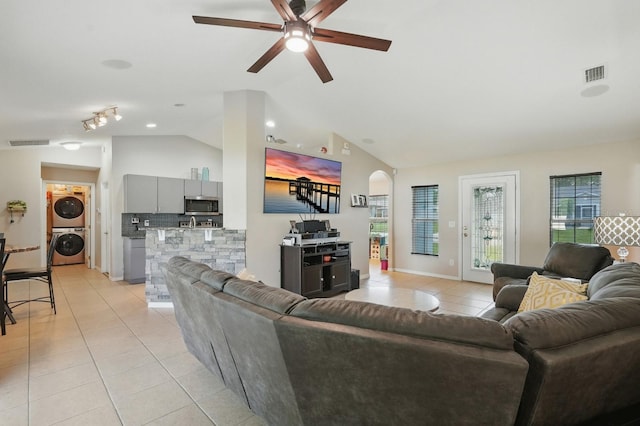8 Severn Ct, Palm Coast, FL 32164 - living room with stacked washer and clothes dryer, light tile patterned floors, vaulted ceiling, a ceiling fan, and arched walkways