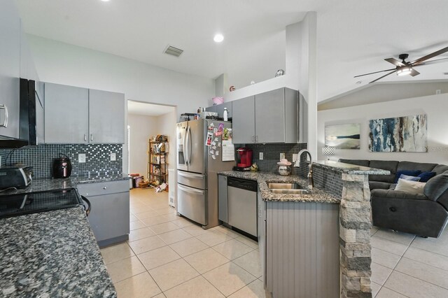 8 Severn Ct, Palm Coast, FL 32164 - kitchen featuring gray cabinetry, stainless steel appliances, open floor plan, decorative backsplash, and dark stone counters