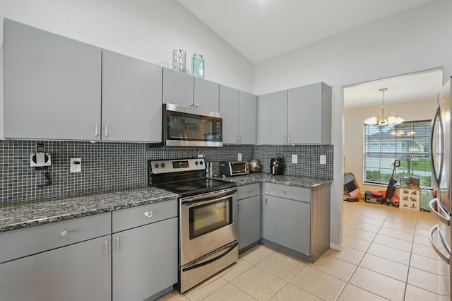 8 Severn Ct, Palm Coast, FL 32164 - kitchen with appliances with stainless steel finishes, gray cabinets, a chandelier, decorative backsplash, and vaulted ceiling