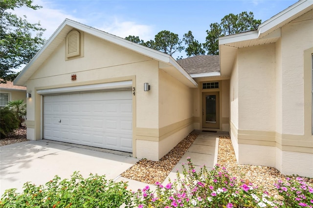 34 Raintree Cir, Palm Coast, FL 32164 - property entrance with a garage, stucco siding, a shingled roof, and concrete driveway