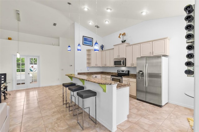 34 Raintree Cir, Palm Coast, FL 32164 - kitchen featuring appliances with stainless steel finishes, a breakfast bar area, high vaulted ceiling, decorative light fixtures, and dark stone countertops