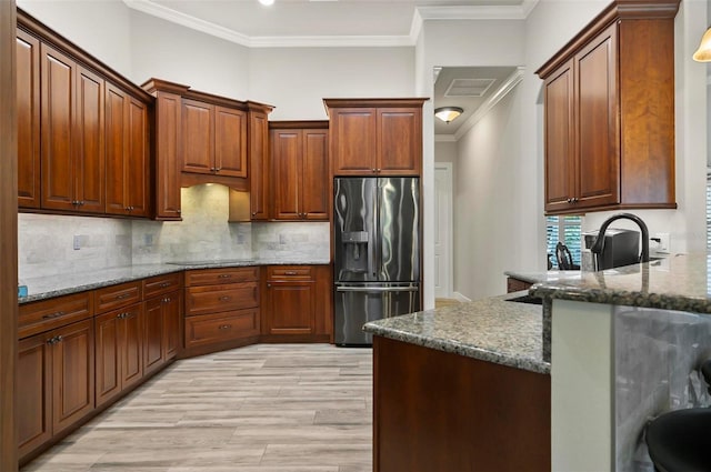 4 Midden Ln, Palm Coast, FL 32137 - kitchen featuring stainless steel fridge, ornamental molding, light wood-style floors, tasteful backsplash, and dark stone counters