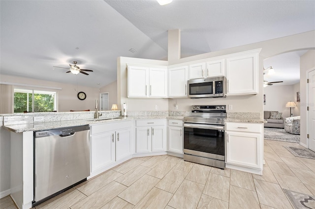 22 Post Tree Ln, Palm Coast, FL 32164 - kitchen featuring appliances with stainless steel finishes, a ceiling fan, vaulted ceiling, a peninsula, and arched walkways