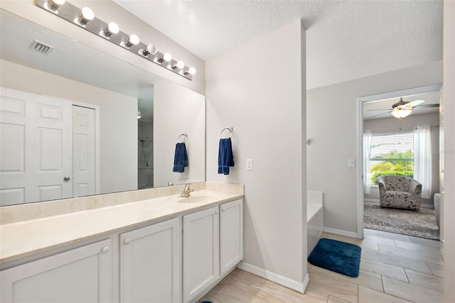 22 Post Tree Ln, Palm Coast, FL 32164 - ensuite bathroom with vanity, a tub, ceiling fan, and a textured ceiling