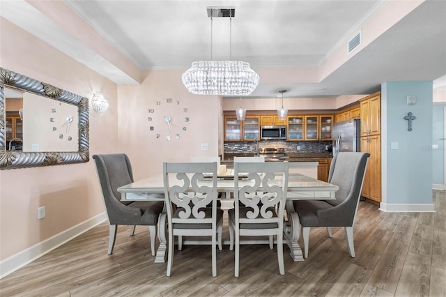 200 Ocean Crest Dr Unit 913, Palm Coast, FL 32137 - dining area with light wood finished floors, a chandelier, ornamental molding, and a tray ceiling