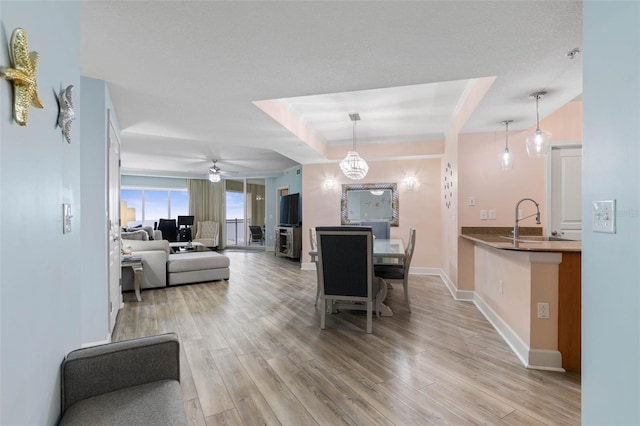 200 Ocean Crest Dr Unit 913, Palm Coast, FL 32137 - dining space with light wood-type flooring, a ceiling fan, and a tray ceiling