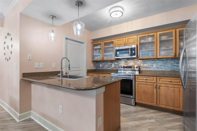 200 Ocean Crest Dr Unit 913, Palm Coast, FL 32137 - kitchen with stainless steel appliances, brown cabinets, light wood-type flooring, and a peninsula