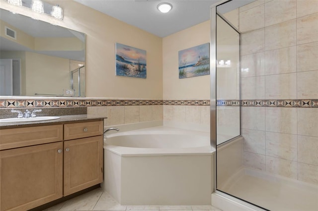 200 Ocean Crest Dr Unit 913, Palm Coast, FL 32137 - full bathroom with tile walls, vanity, a garden tub, a stall shower, and tile patterned floors
