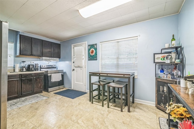 418 NW 27th Ter, Gainesville, FL 32607 - kitchen with electric range, under cabinet range hood, ornamental molding, and dark brown cabinetry