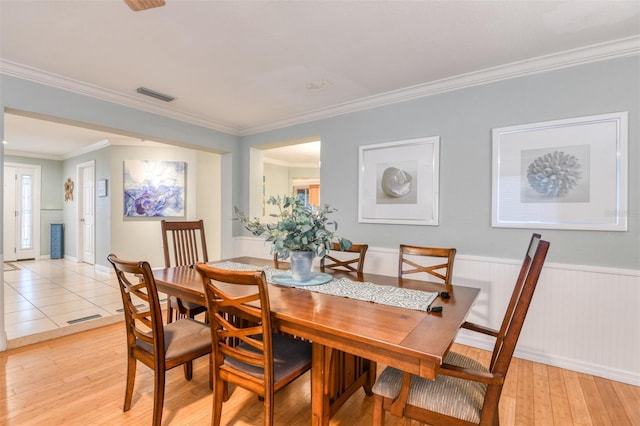 159 Southwind Cir, Saint Augustine, FL 32080 - dining room featuring light wood finished floors, crown molding, and wainscoting