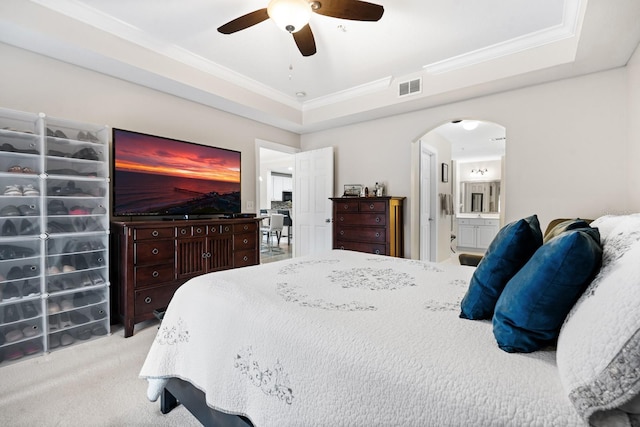 100 Bella Harbor Ct Unit 103, Palm Coast, FL 32137 - carpeted bedroom with arched walkways, ornamental molding, ensuite bathroom, a tray ceiling, and ceiling fan