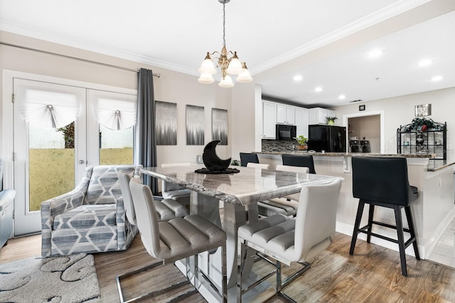 100 Bella Harbor Ct Unit 103, Palm Coast, FL 32137 - dining space with a chandelier, light wood-style flooring, recessed lighting, and ornamental molding