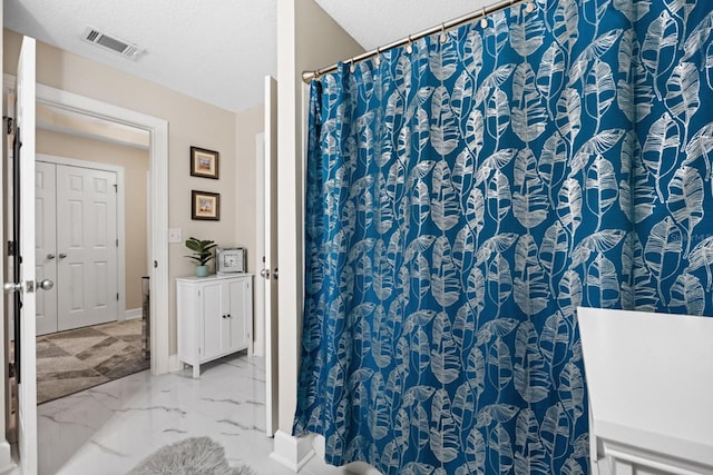 100 Bella Harbor Ct Unit 103, Palm Coast, FL 32137 - bathroom with a shower with shower curtain, marble look tiles, and a textured ceiling