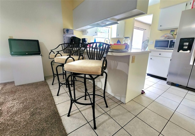 1561 Copperfield Ave, Deltona, FL 32738 - kitchen with appliances with stainless steel finishes, white cabinets, light countertops, a peninsula, and light tile patterned flooring