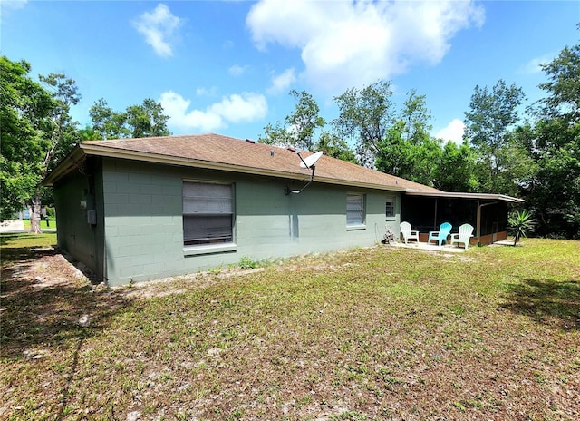 1561 Copperfield Ave, Deltona, FL 32738 - back of property featuring concrete block siding, a yard, and a shingled roof