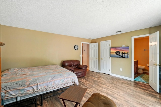 29 Rylin Ln, Palm Coast, FL 32164 - bedroom featuring wood finished floors, a textured ceiling, connected bathroom, and a closet