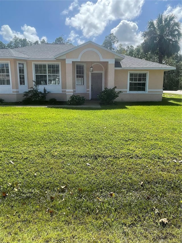 2 Unity Ct, Palm Coast, FL 32164 - ranch-style house with stucco siding and a front yard