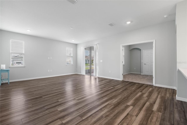 51 Oakleaf Way, Palm Coast, FL 32137 - unfurnished living room featuring dark wood-style flooring, recessed lighting, and arched walkways