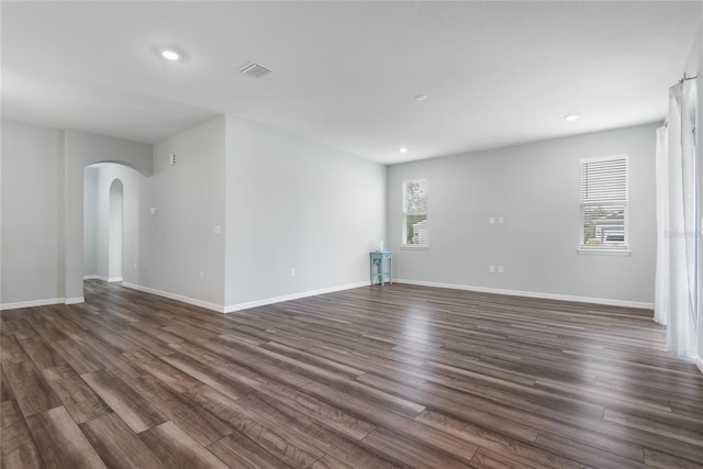 51 Oakleaf Way, Palm Coast, FL 32137 - empty room featuring arched walkways, dark wood-style floors, and recessed lighting