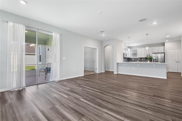 51 Oakleaf Way, Palm Coast, FL 32137 - unfurnished living room with dark wood-type flooring, arched walkways, and recessed lighting
