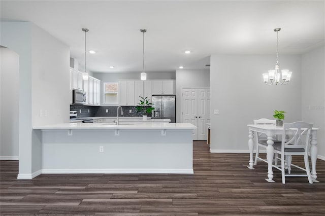 51 Oakleaf Way, Palm Coast, FL 32137 - kitchen with appliances with stainless steel finishes, a peninsula, dark wood-style floors, light countertops, and recessed lighting