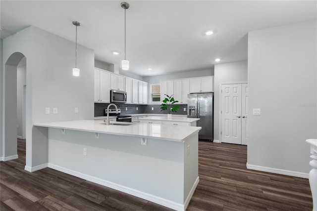 51 Oakleaf Way, Palm Coast, FL 32137 - kitchen with appliances with stainless steel finishes, a peninsula, dark wood finished floors, arched walkways, and recessed lighting
