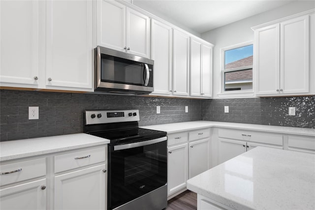 51 Oakleaf Way, Palm Coast, FL 32137 - kitchen with stainless steel microwave, electric stove, white cabinetry, tasteful backsplash, and light stone countertops