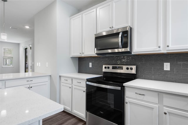 51 Oakleaf Way, Palm Coast, FL 32137 - kitchen with stainless steel microwave, electric stove, white cabinetry, dark wood-style floors, and backsplash