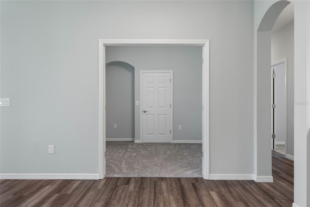 51 Oakleaf Way, Palm Coast, FL 32137 - empty room with arched walkways and dark wood-style flooring
