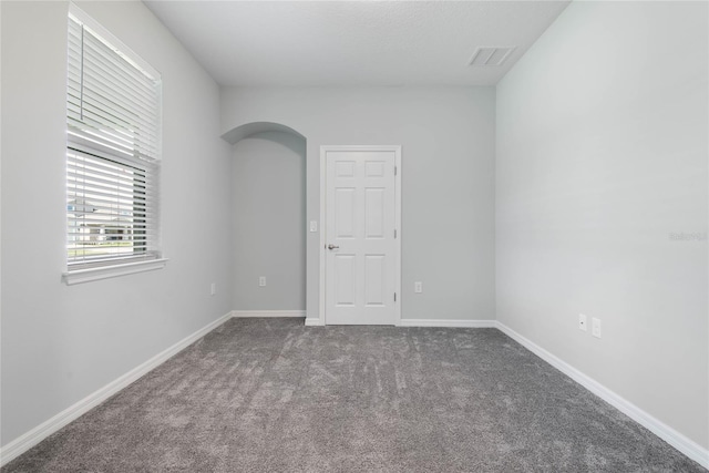51 Oakleaf Way, Palm Coast, FL 32137 - empty room with arched walkways and carpet