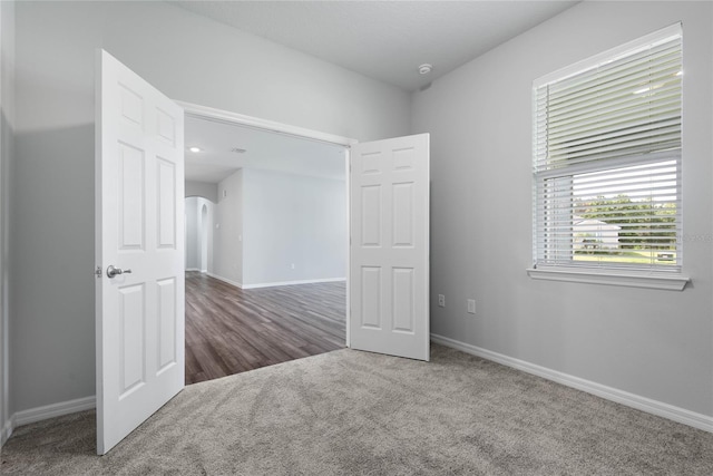 51 Oakleaf Way, Palm Coast, FL 32137 - empty room featuring carpet, arched walkways, and a smoke detector