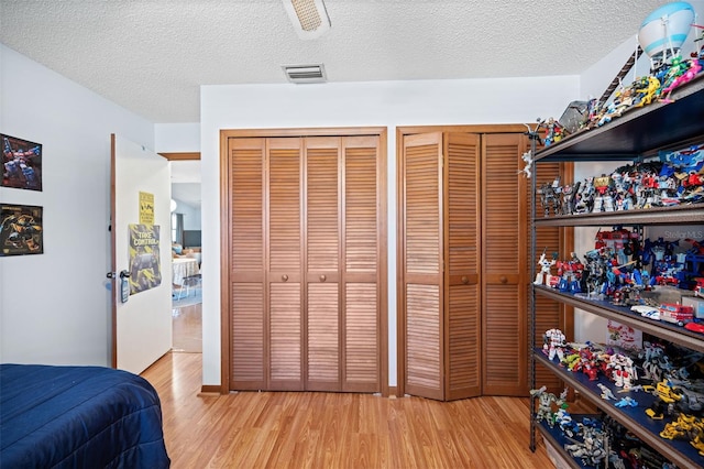 152 Fenimore Ln Unit A & B, Palm Coast, FL 32137 - bedroom with wood finished floors, two closets, a textured ceiling, and a ceiling fan