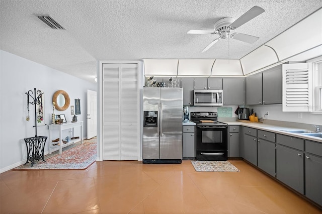 152 Fenimore Ln Unit A & B, Palm Coast, FL 32137 - kitchen featuring appliances with stainless steel finishes, gray cabinetry, a textured ceiling, a ceiling fan, and light countertops