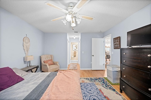 152 Fenimore Ln Unit A & B, Palm Coast, FL 32137 - bedroom with light wood-style floors, a textured ceiling, connected bathroom, and ceiling fan
