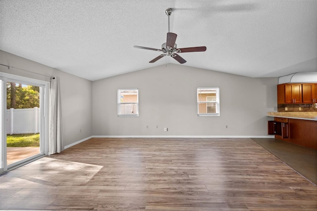 152 Fenimore Ln Unit A & B, Palm Coast, FL 32137 - unfurnished living room featuring a textured ceiling, a ceiling fan, plenty of natural light, wood finished floors, and lofted ceiling