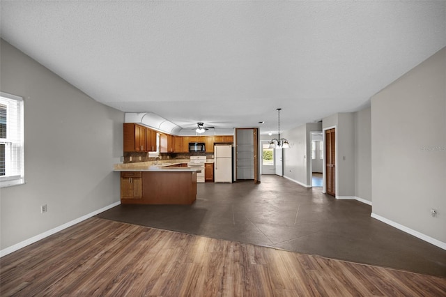 152 Fenimore Ln Unit A & B, Palm Coast, FL 32137 - kitchen featuring white appliances, brown cabinetry, a peninsula, open floor plan, and light countertops