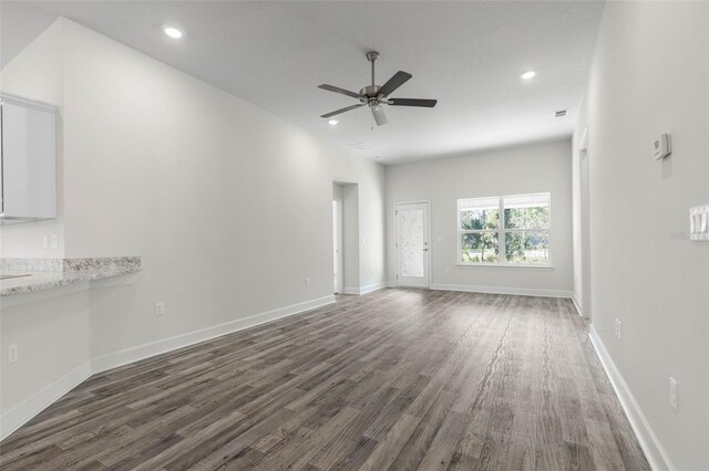 6 Bainbridge Ln, Palm Coast, FL 32137 - unfurnished living room featuring dark wood-style flooring, ceiling fan, and recessed lighting