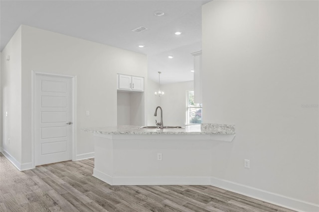 6 Bainbridge Ln, Palm Coast, FL 32137 - kitchen featuring light wood-type flooring, a peninsula, white cabinets, light stone counters, and recessed lighting