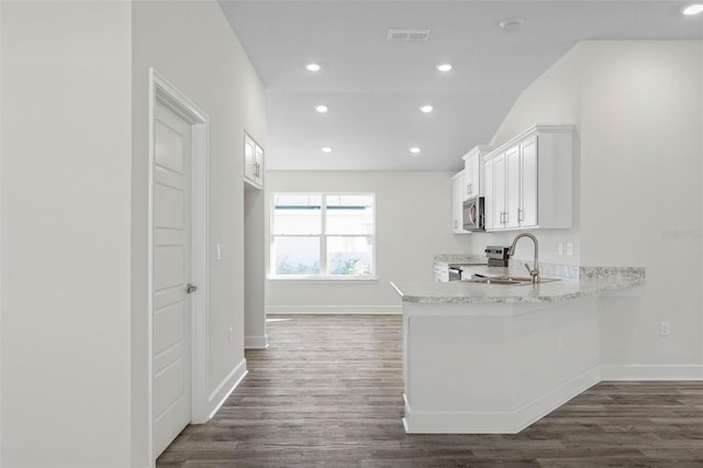 6 Bainbridge Ln, Palm Coast, FL 32137 - kitchen with stainless steel appliances, dark wood-style floors, white cabinetry, recessed lighting, and a peninsula