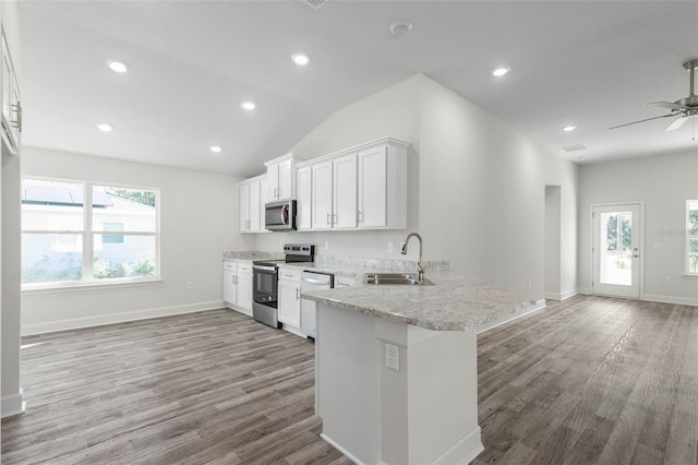 6 Bainbridge Ln, Palm Coast, FL 32137 - kitchen featuring appliances with stainless steel finishes, open floor plan, wood finished floors, white cabinetry, and a peninsula