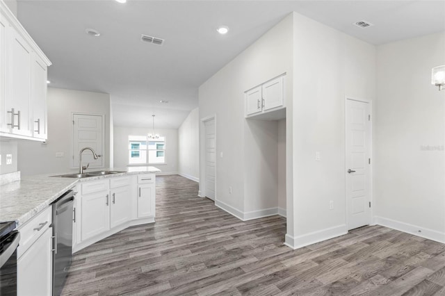 6 Bainbridge Ln, Palm Coast, FL 32137 - kitchen featuring stainless steel dishwasher, a chandelier, a peninsula, wood finished floors, and white cabinetry