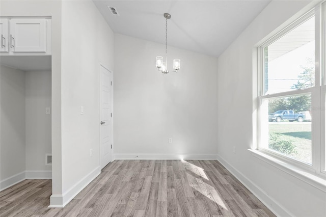6 Bainbridge Ln, Palm Coast, FL 32137 - unfurnished dining area with a chandelier, light wood-style floors, and vaulted ceiling