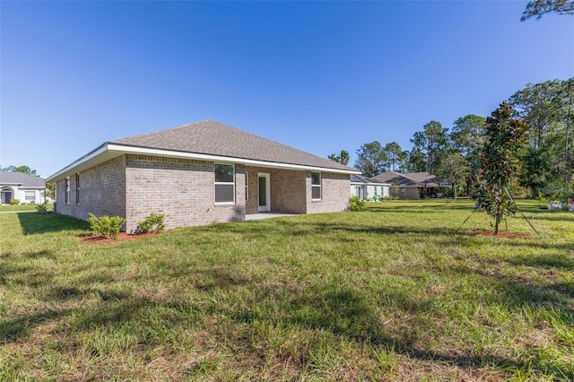 6 Bainbridge Ln, Palm Coast, FL 32137 - rear view of property featuring brick siding and a lawn
