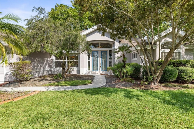 81 Brownstone Ln, Palm Coast, FL 32137 - view of front of home with french doors, stucco siding, and a front lawn