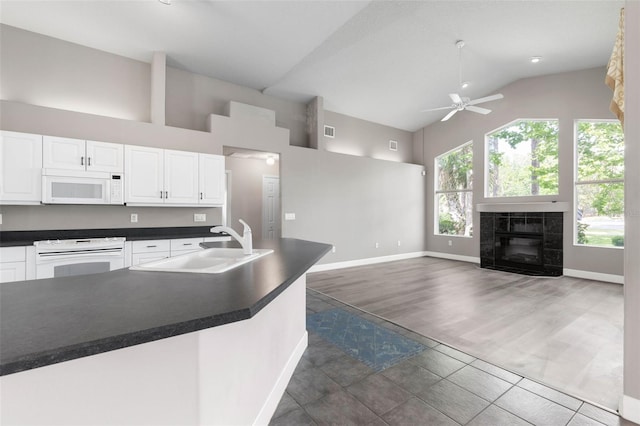 81 Brownstone Ln, Palm Coast, FL 32137 - kitchen with white appliances, high vaulted ceiling, ceiling fan, dark countertops, and white cabinetry