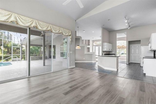 81 Brownstone Ln, Palm Coast, FL 32137 - unfurnished living room with ceiling fan, wood finished floors, and vaulted ceiling